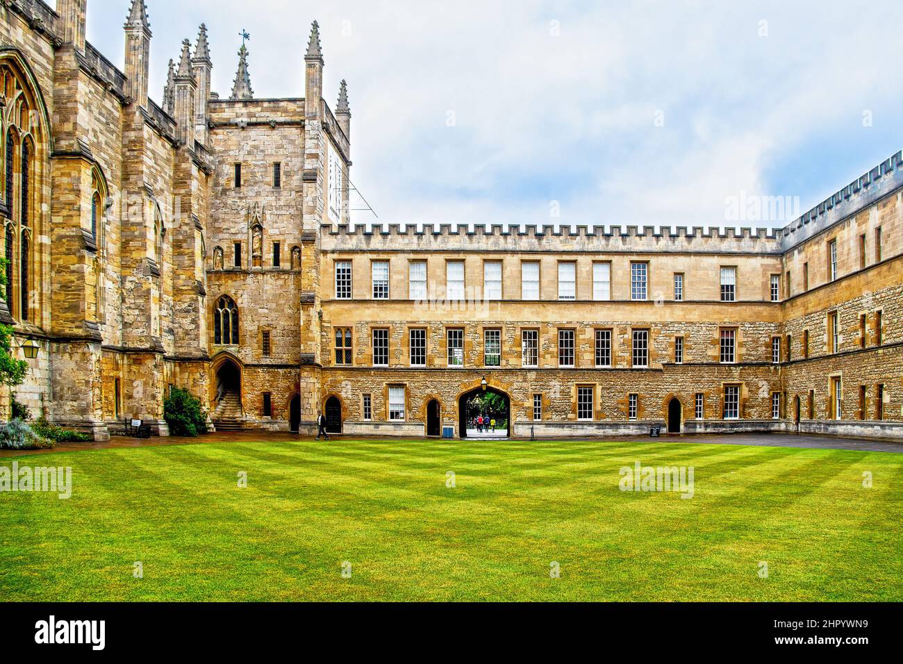 07-2019 Oxford UK - das New College Quad mit knusprig gemähtem Gras und einigen Studenten, die an einem schönen Sommertag an der Oxford University durch den Bogen gehen. Stockfoto