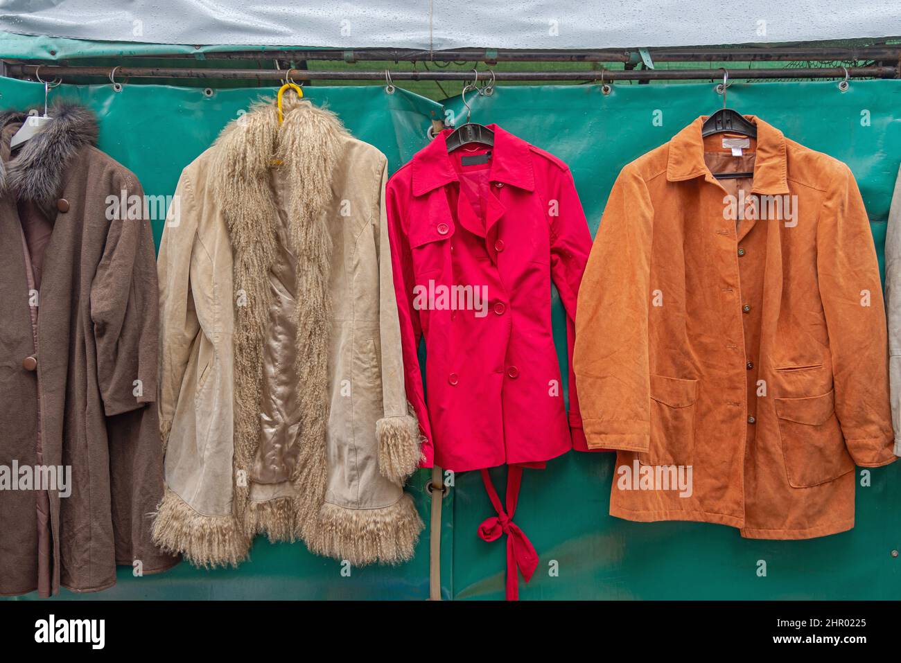 Roter Trenchcoat und Jackets auf dem Flohmarkt Stockfoto
