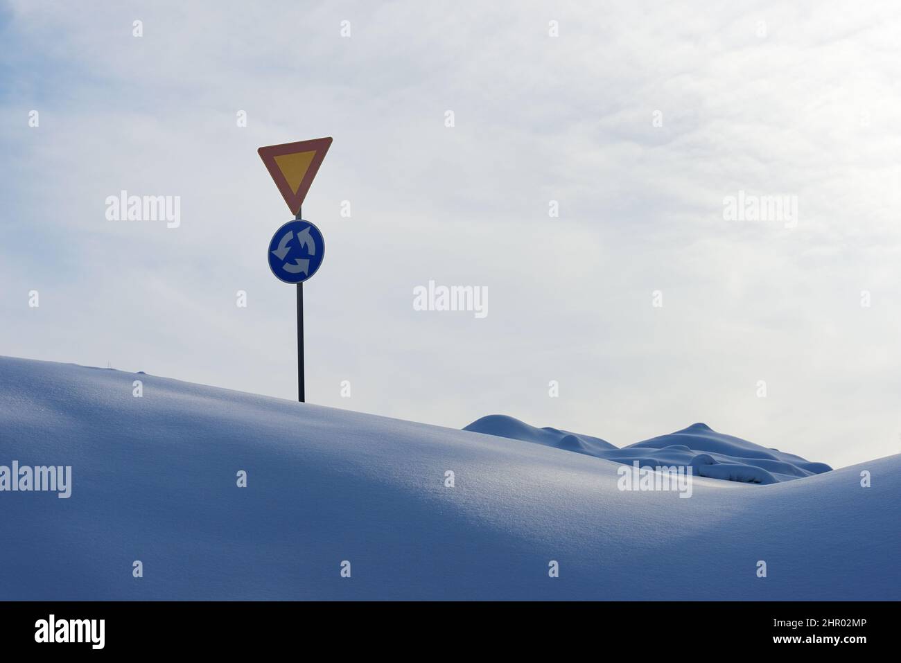 Kreisverkehr Zeichen und geben im Winter zwischen Schneeverwehungen irgendwo in Finnland Stockfoto