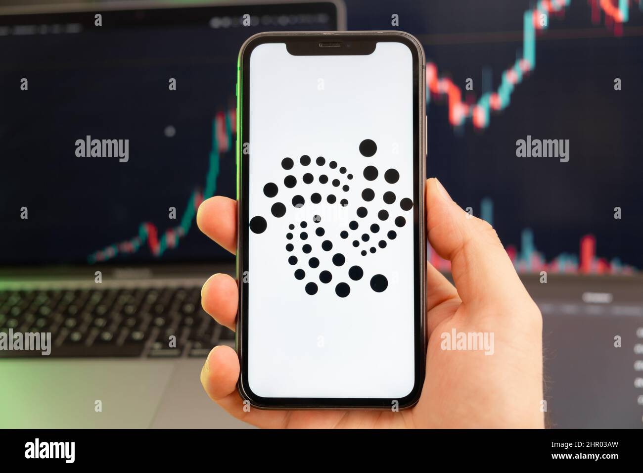 IOTA MIOTA App der Kryptowährung Aktienmarktanalyse auf dem Bildschirm des Mobiltelefons in Menschenhand und wachsenden Charts Trading-Daten im Hintergrund, Februar 2022, San Francisco, USA. Stockfoto