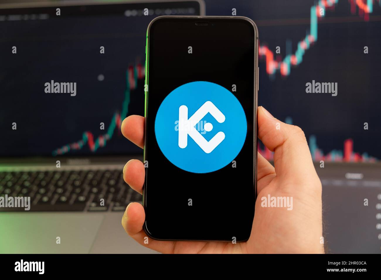 KuCoin Token KCS App der Kryptowährung Aktienmarktanalyse auf dem Bildschirm des Mobiltelefons in Menschenhand und wachsenden Charts Handelsdaten im Hintergrund, Februar 2022, San Francisco, USA. Stockfoto