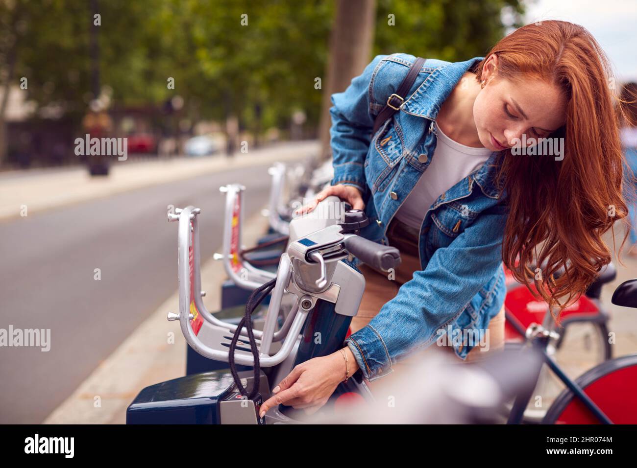 Junge Frau, Die Fahrrad Als Grüne Form Des Verkehrs Mietet, Um Sich In Der Stadt Zu Bewegen Stockfoto