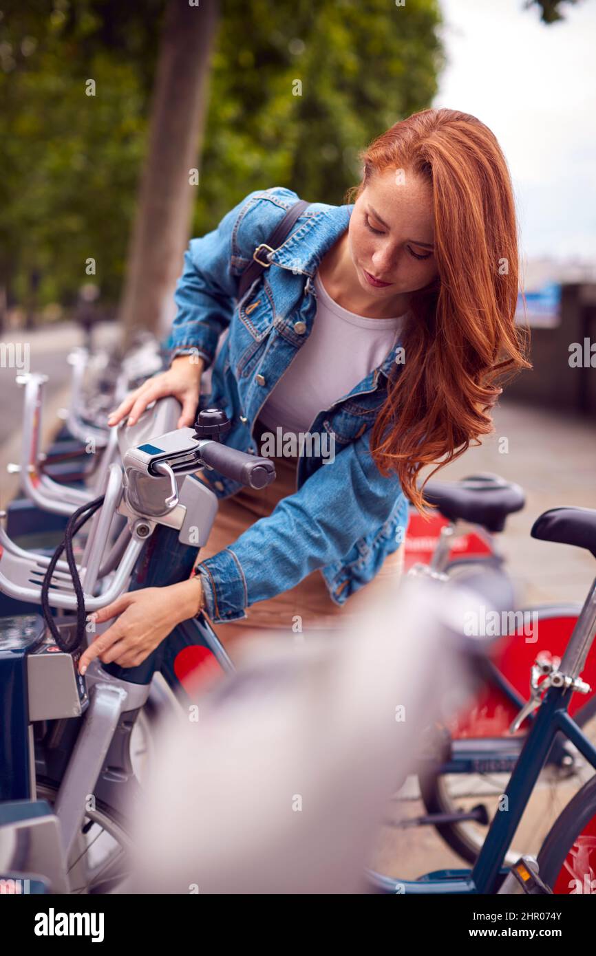 Junge Frau, Die Fahrrad Als Grüne Form Des Verkehrs Mietet, Um Sich In Der Stadt Zu Bewegen Stockfoto