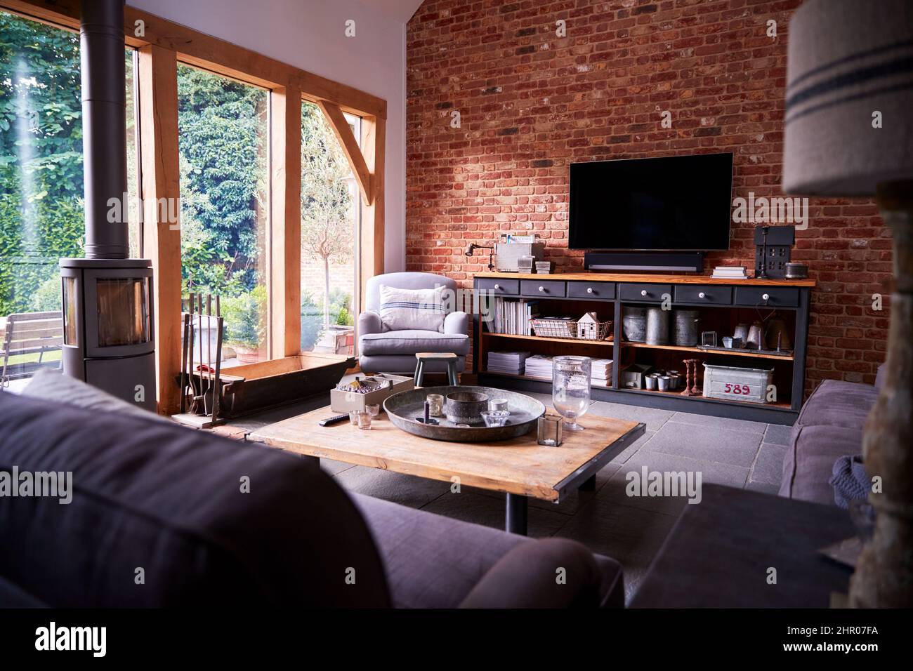 Interieur der Lounge mit TV und freiliegenden Backsteinwänden im modernen Open Plan House oder Apartment Stockfoto