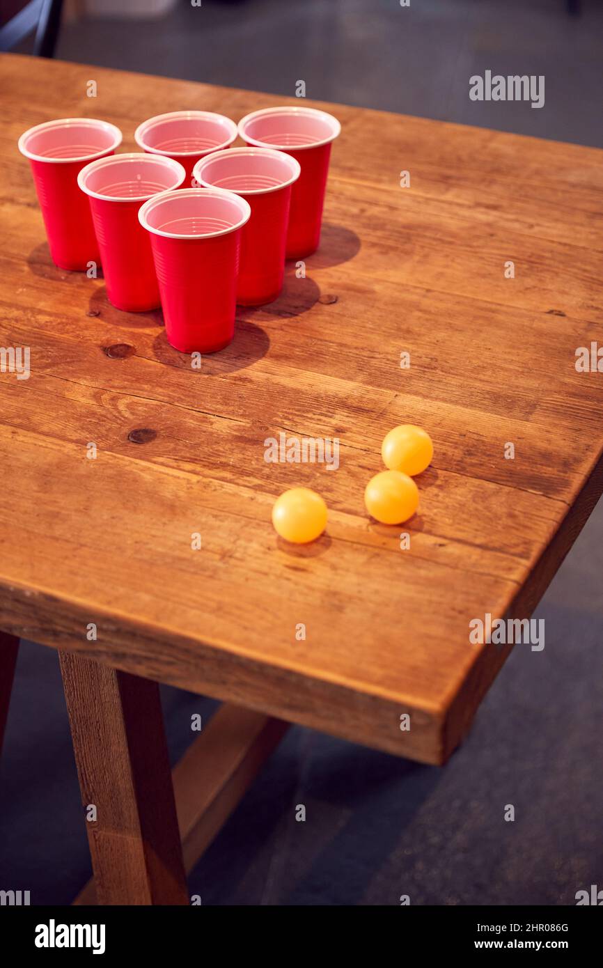 Plastikbecher Und Kugeln Auf Holztisch Bereit Für Party-Spiel Zu Hause Stockfoto