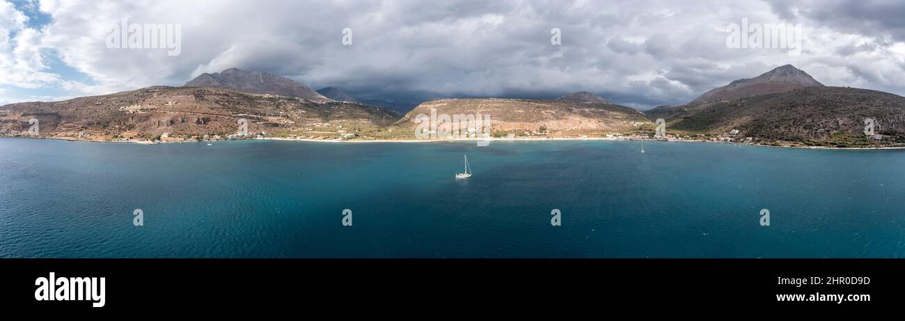 Griechenland, Peloponnes. Laconia Mani Bucht, Küste, Fischerdorf am Meer unter starkem Wolkenhimmel, Panoramablick aus der Luft Stockfoto