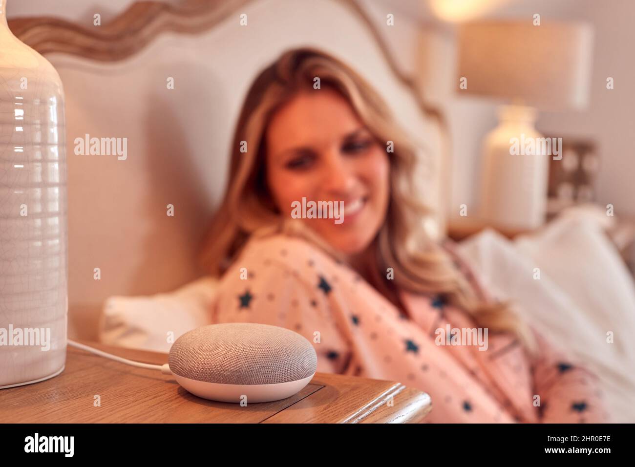 Frau Zu Hause Im Bett Mit Digitalem Personal Assistant Stockfoto