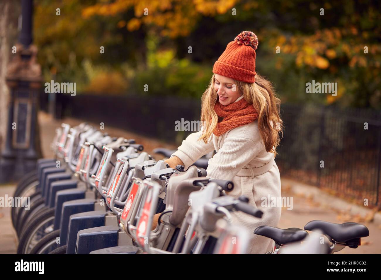 Junge Frau, Die Fahrrad Als Grüne Transportform Mietet, Um Im Herbst Oder Herbst In Der Stadt Herumzukommen Stockfoto