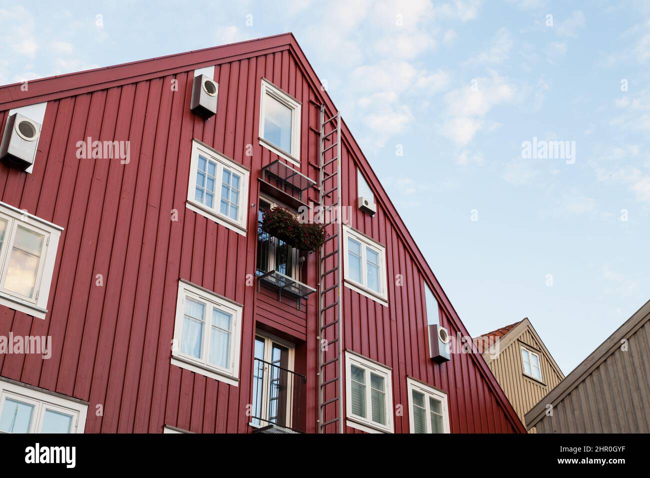 Wand aus rotem Holzhaus mit Fenstern und Leiter, traditionelle norwegische Architektur Stockfoto