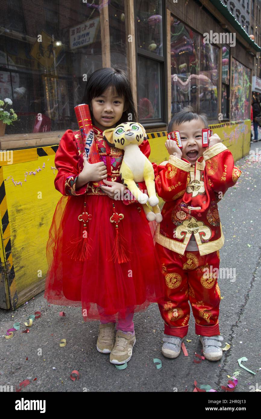 Kinder, die am besten in traditionellem Chinesisch gekleidet sind, feiern das chinesische Neujahr auf der Straße in Chinatown, New York City. Stockfoto