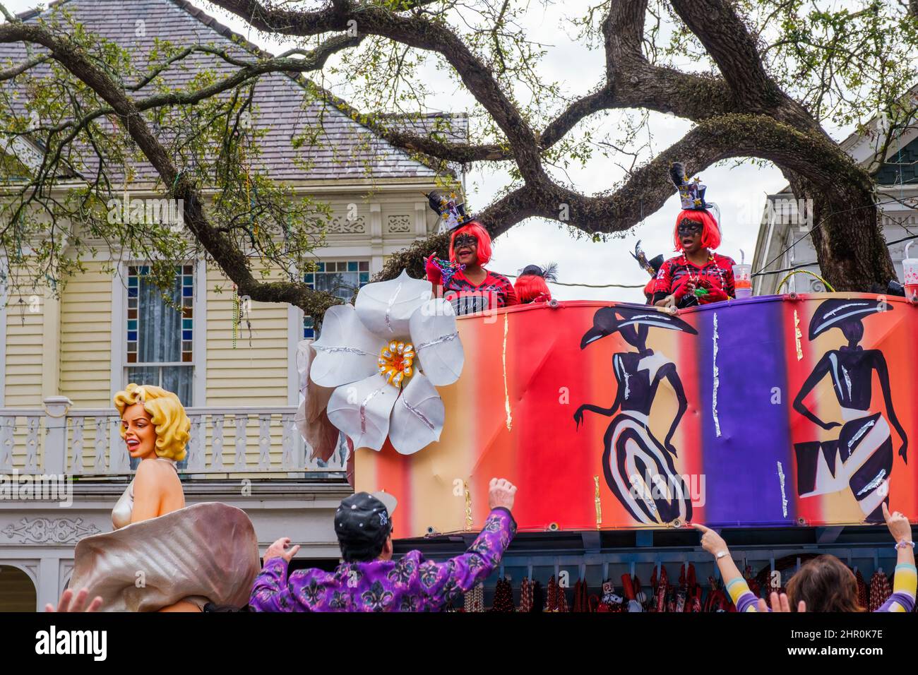 NEW ORLEANS, LA, USA - 20. FEBRUAR 2022: Femme Fatale Parade mit Fahrern passiert Häuser und winkende Zuschauer auf der St. Charles Avenue Stockfoto