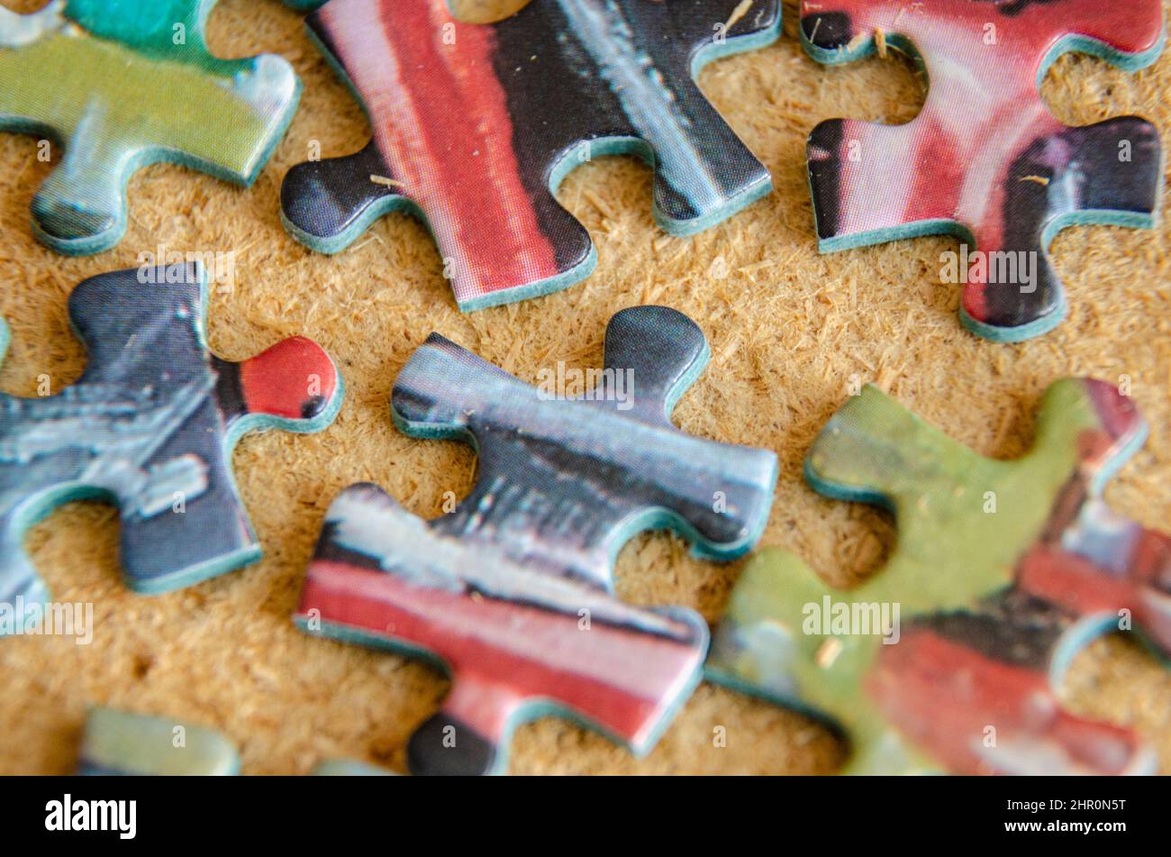 Nahaufnahme von Puzzleteilen, die auf einem kalkbeschlagten Hintergrund verstreut sind. Stockfoto