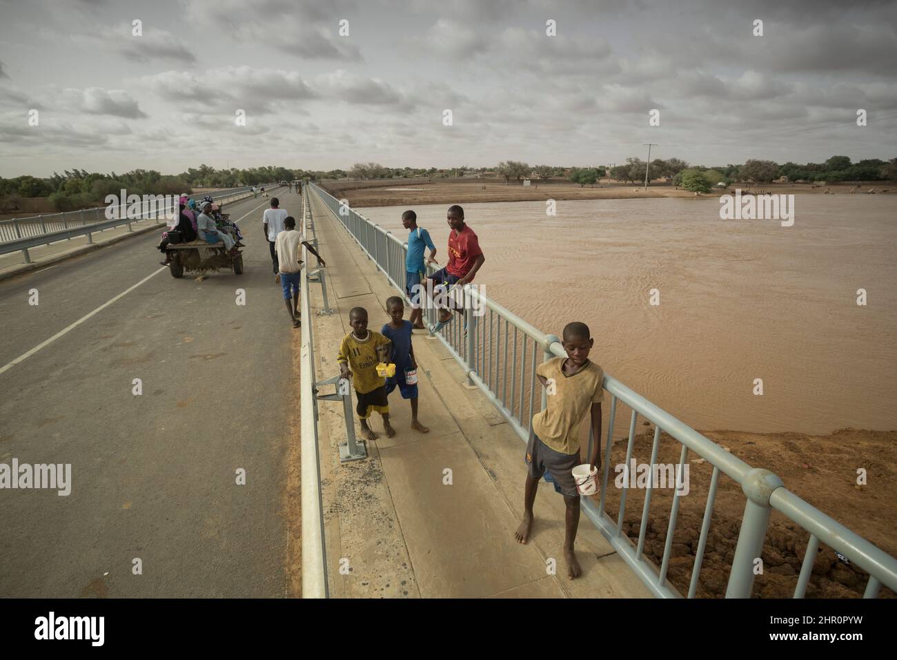 Kinder stehen auf der Ndioum Bridge, die den Doué River überspannt und die Stadt Ndioum mit Morphil Island im nördlichen Senegal, W. Africa verbindet. Stockfoto