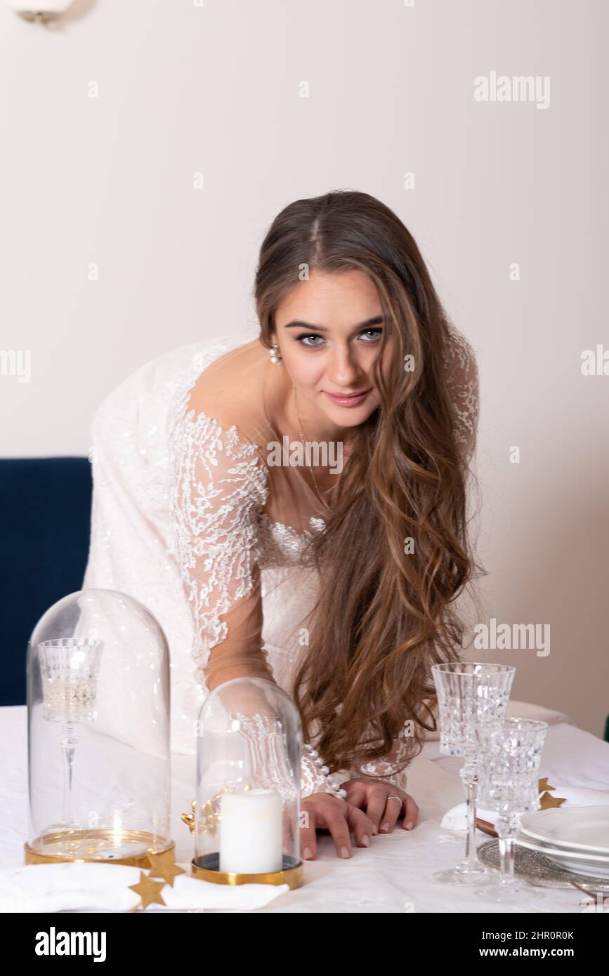 Die Braut kriecht wie eine Katze auf den Tisch. Hochwertige Fotos Stockfoto