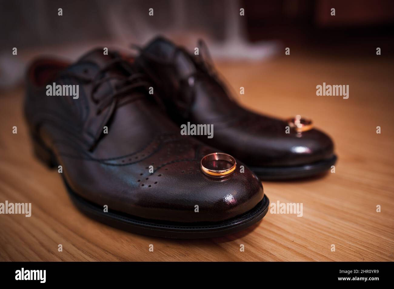 Lederschuhe für Herren, ein Paar goldene Eheringe in einer Holzkiste. Accessoires des Bräutigams Stockfoto