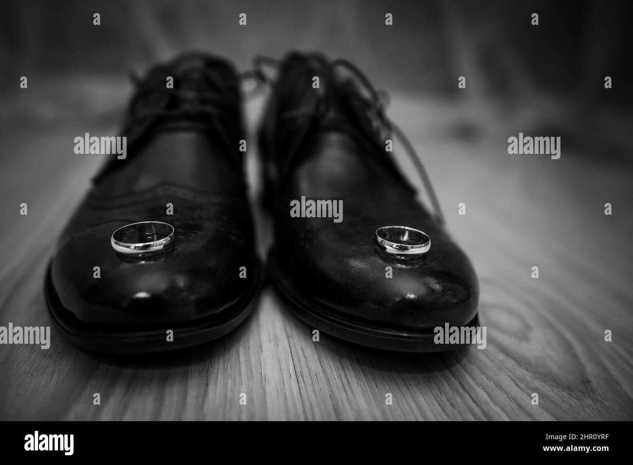 Lederschuhe für Herren, ein Paar goldene Eheringe in einer Holzkiste. Accessoires des Bräutigams Stockfoto