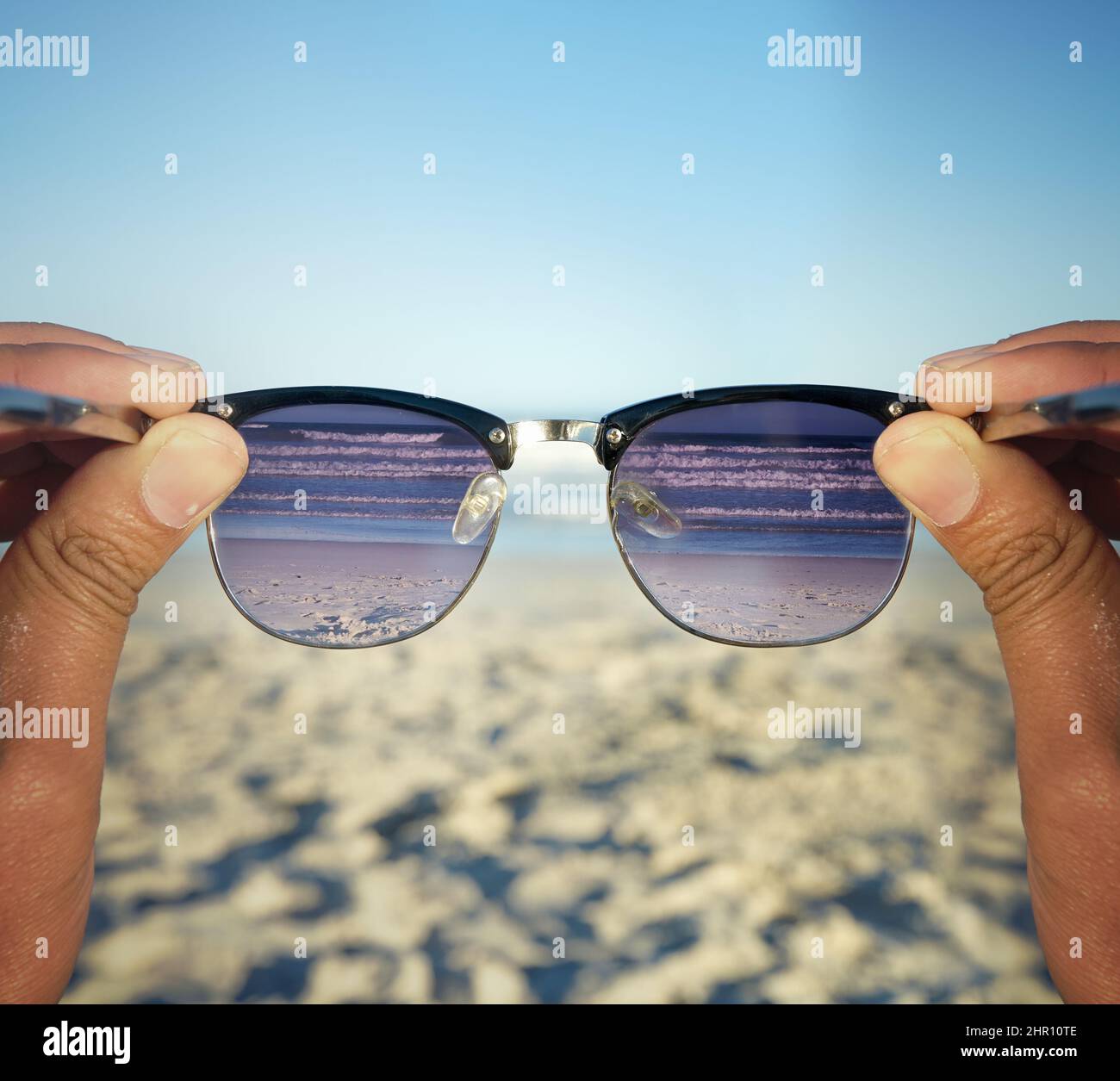 Am Strand ist das Leben besser. POV-Aufnahme einer Person am Strand, die durch ihre Sonnenbrille auf die Wellen schaute. Stockfoto