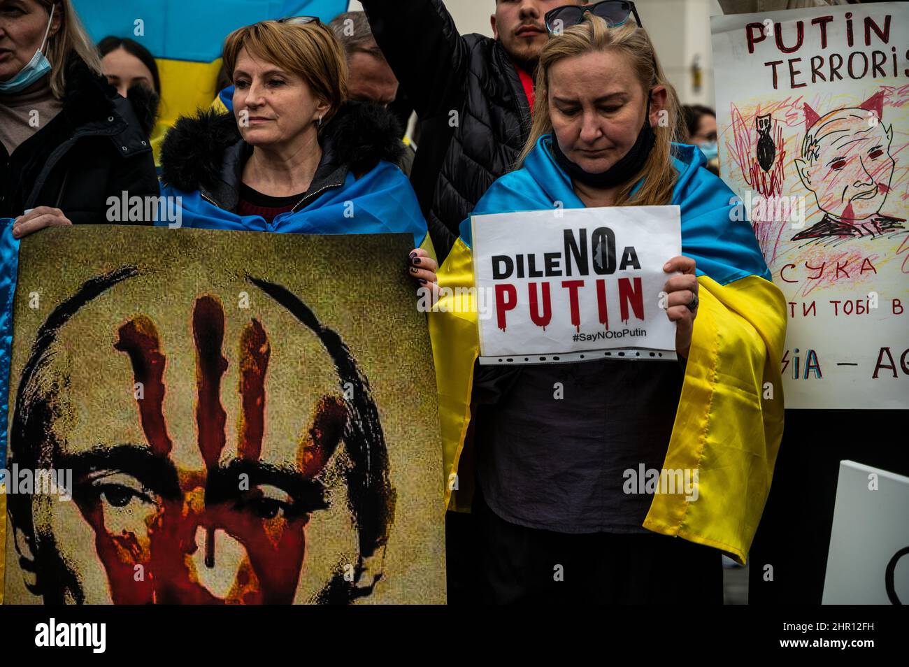 Madrid, Spanien. 24th. Februar 2022. Menschen protestieren mit Plakaten nach den ersten russischen Angriffen, die in der Ukraine registriert wurden. In Madrid lebende Ukrainer versammelten sich vor der russischen Botschaft, um gegen die in mehreren Teilen des ukrainischen Landes registrierten russischen Angriffe zu protestieren, die das Ende des Krieges forderten und Parolen gegen den russischen Präsidenten Wladimir Putin riefen. Quelle: Marcos del Mazo/Alamy Live News Stockfoto