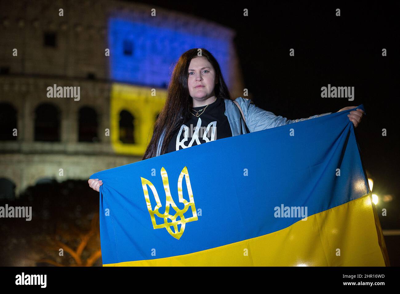 Rom Roma, Italien Italia. 24.. Februar 2022. Rom, 24.. Februar 2022. Die ukrainische Flagge wurde auf die Wände des Kolosseums in Rom projiziert, wo sich Menschen aus der ukrainischen Gemeinschaft versammelten, um ihre Fahnen zu schwingen, um gegen den Krieg gegen die Ukraine zu protestieren, der heute Morgen vom russischen Präsidenten Wladimir Putin erklärt wurde. Kredit: LSF Foto/Alamy Live Nachrichten Stockfoto