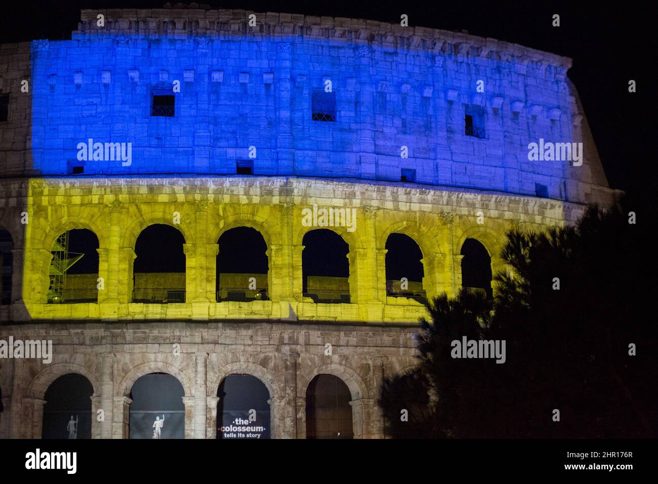 Rom Roma, Italien Italia. 24.. Februar 2022. Rom, 24.. Februar 2022. Die ukrainische Flagge wurde auf die Wände des Kolosseums in Rom projiziert, wo sich Menschen aus der ukrainischen Gemeinschaft versammelten, um ihre Fahnen zu schwingen, um gegen den Krieg gegen die Ukraine zu protestieren, der heute Morgen vom russischen Präsidenten Wladimir Putin erklärt wurde. Kredit: LSF Foto/Alamy Live Nachrichten Stockfoto