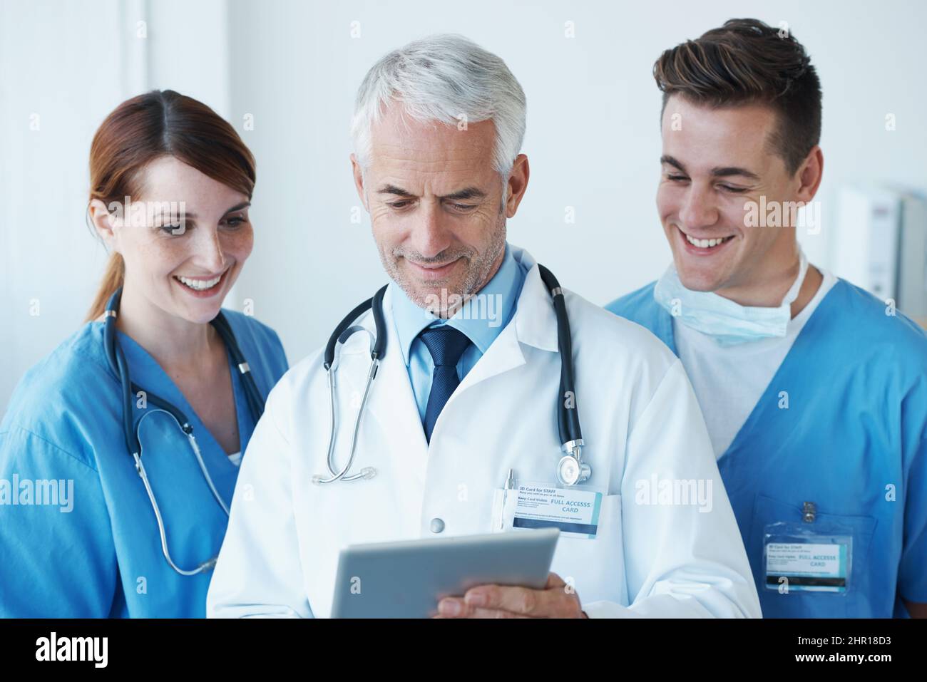 Das sieht gut aus. Drei Mediziner diskutieren über Informationen, die auf einem digitalen Tablet präsentiert werden. Stockfoto