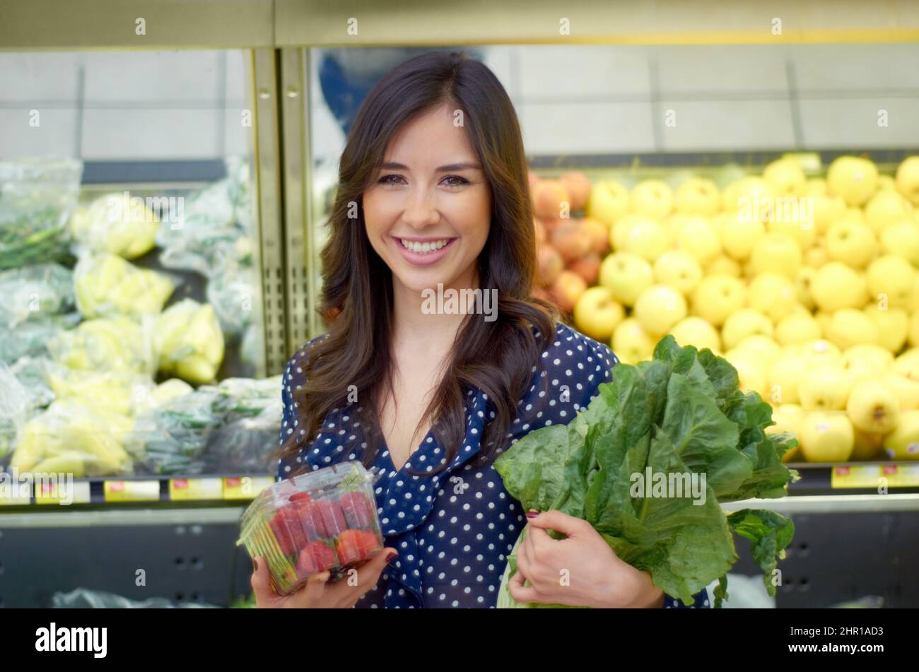 Mein Lieblingsgang. Eine junge Frau, die lächelt, während sie Gemüse kauft. Stockfoto