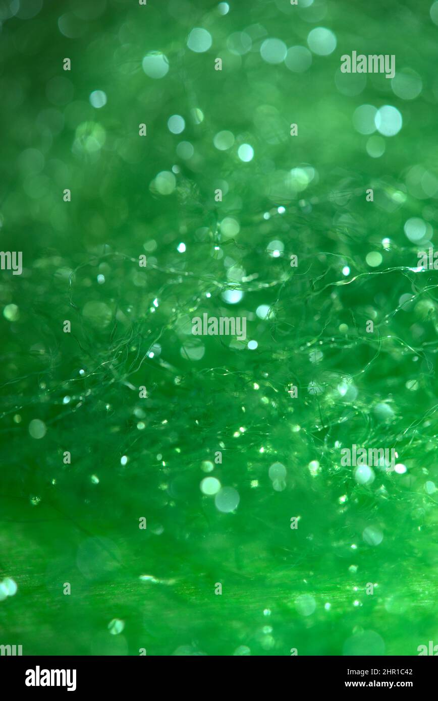 Verworrener, glänzender, grüner Hintergrund aus Synthetikfasern in Makroaufnahmen Stockfoto
