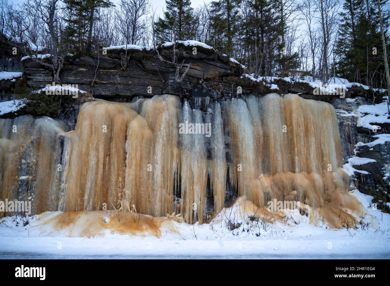 Gefrorene Wasserfälle mit brauner Humussäure, Norwegen, Troms Stockfoto