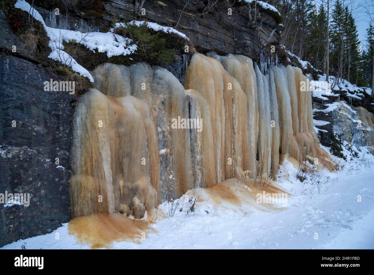Gefrorene Wasserfälle mit brauner Humussäure, Norwegen, Troms Stockfoto