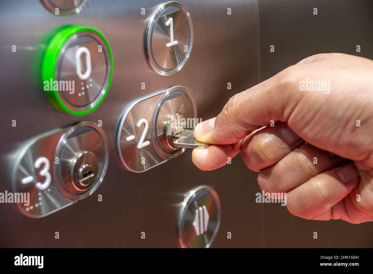 Lift access control. Hand mit einem Schlüssel zu Fahrstuhl Etage Stockfoto