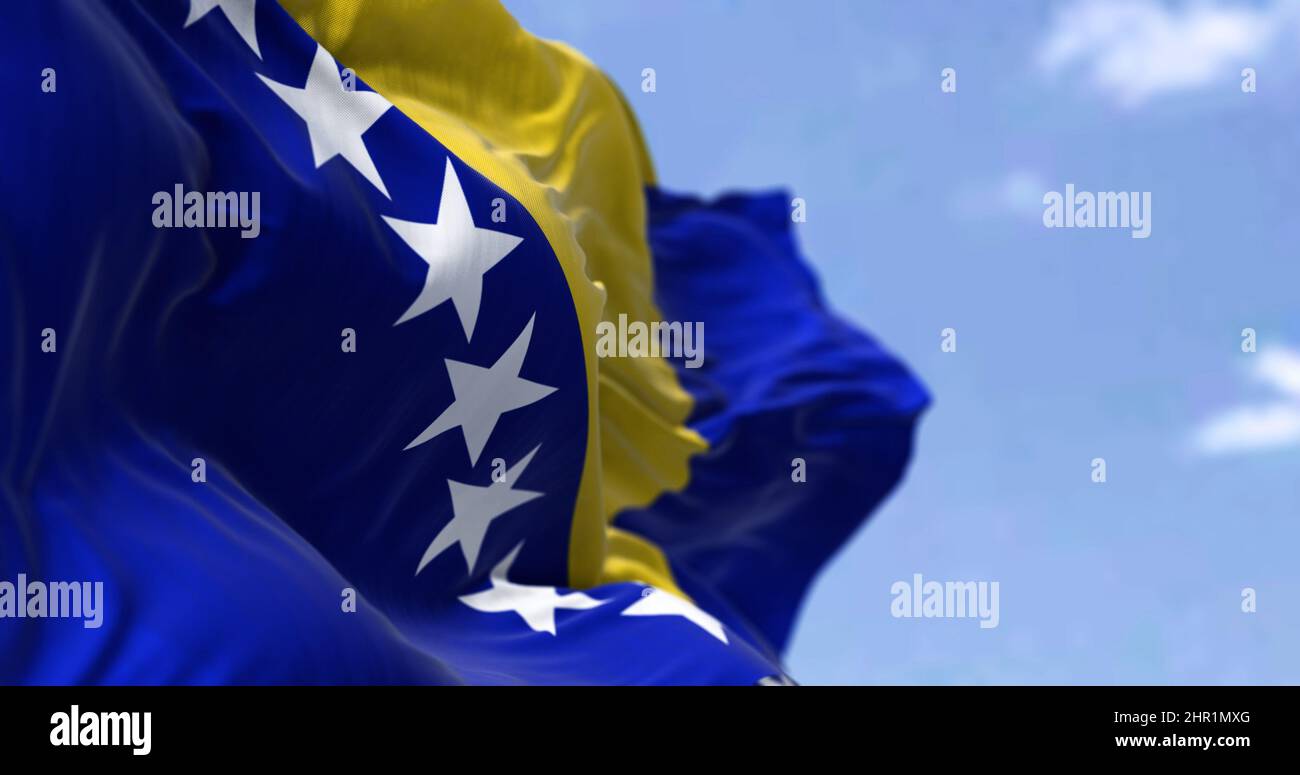 Detail der Nationalflagge von Bosnien und Herzegowina, die an einem klaren Tag im Wind winkt. Demokratie und Politik. Selektiver Fokus. Bosnien ist ein Land Stockfoto
