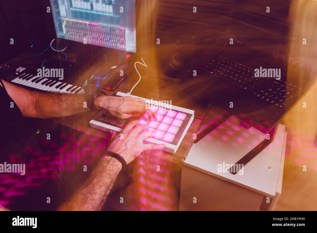 Licht Malerei Bild von kaukasischen Mann arbeiten in Home-Musik-Studio, buntes Bild für Musik Konzept Grafik Ressource, mit Tastatur, Notebook-Rechner Stockfoto
