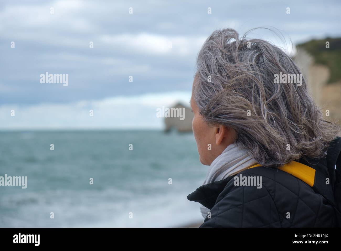 Profilansicht einer älteren Frau am kalten Strand Stockfoto