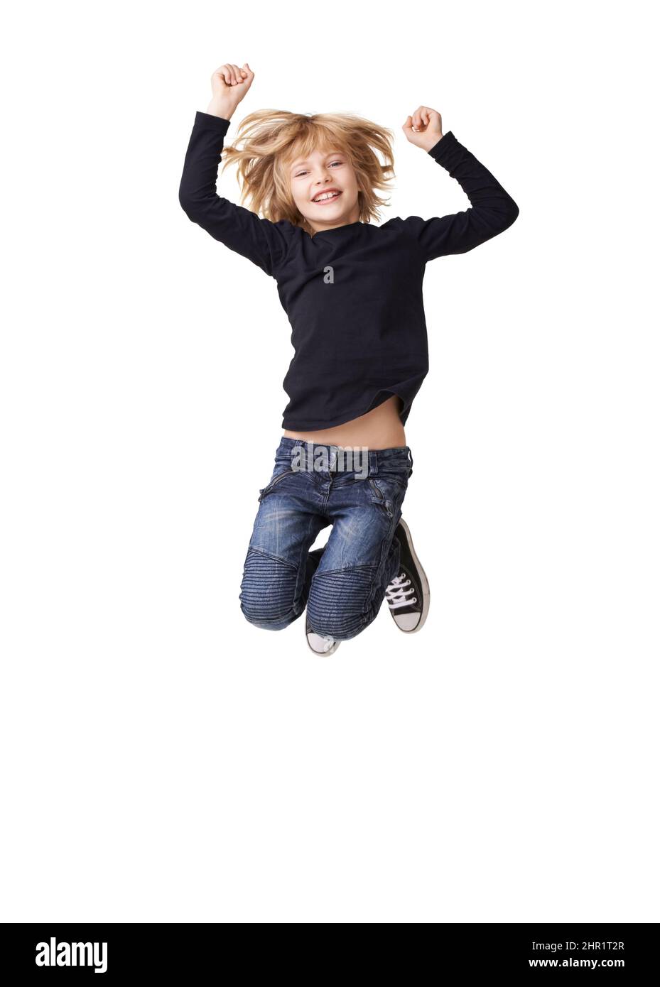 Schulen aus. Porträt eines hübschen kleinen Mädchens, das lächelt und mit in der Luft erhobenen Armen vor weißem Hintergrund springt. Stockfoto