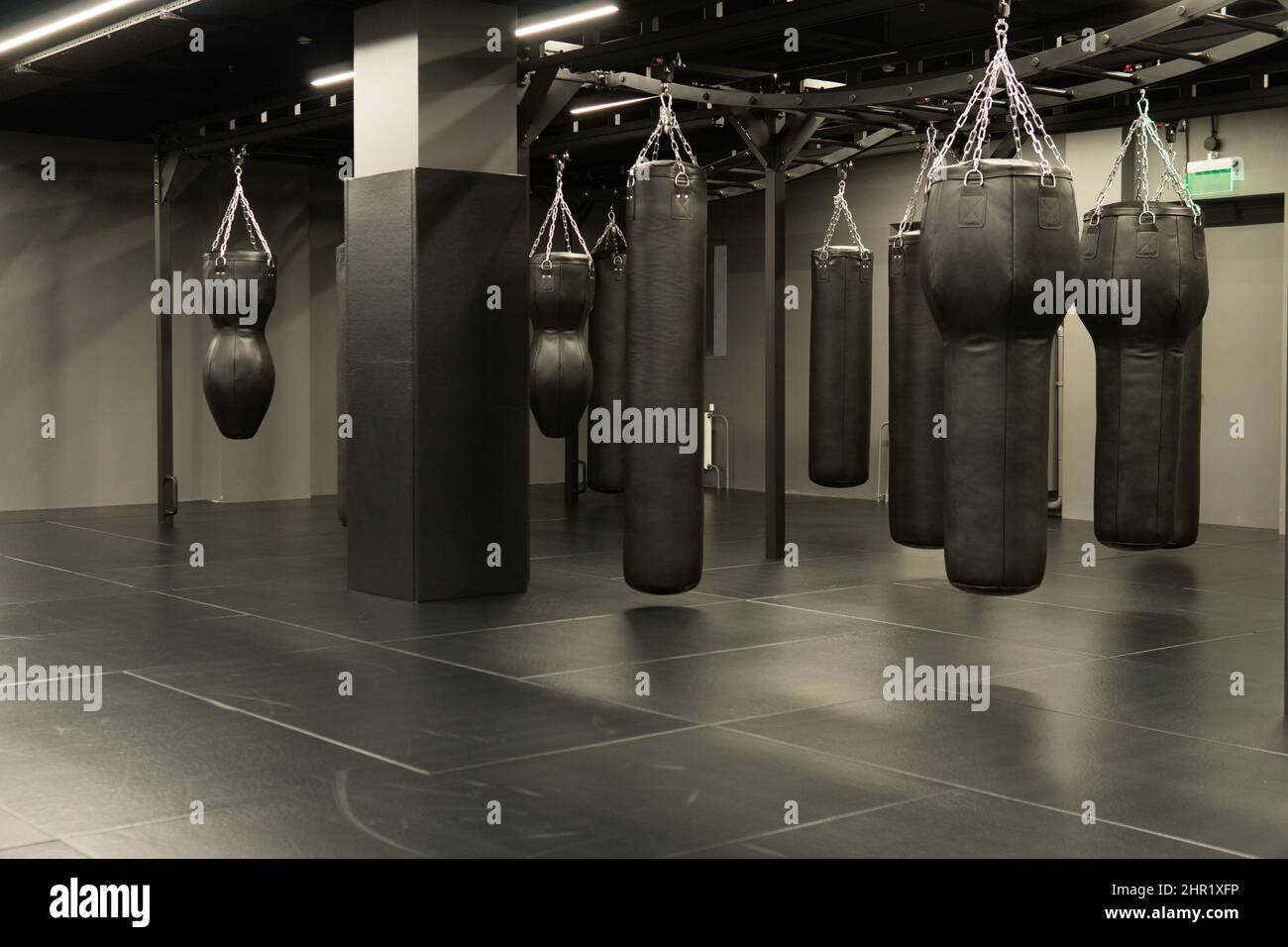 Boxtraining im Taschenboxing, für Wettkampf tritt für Schlag für Säcke Schlag, roter Schläger. Ruftonaktivität dunkel, Stockfoto