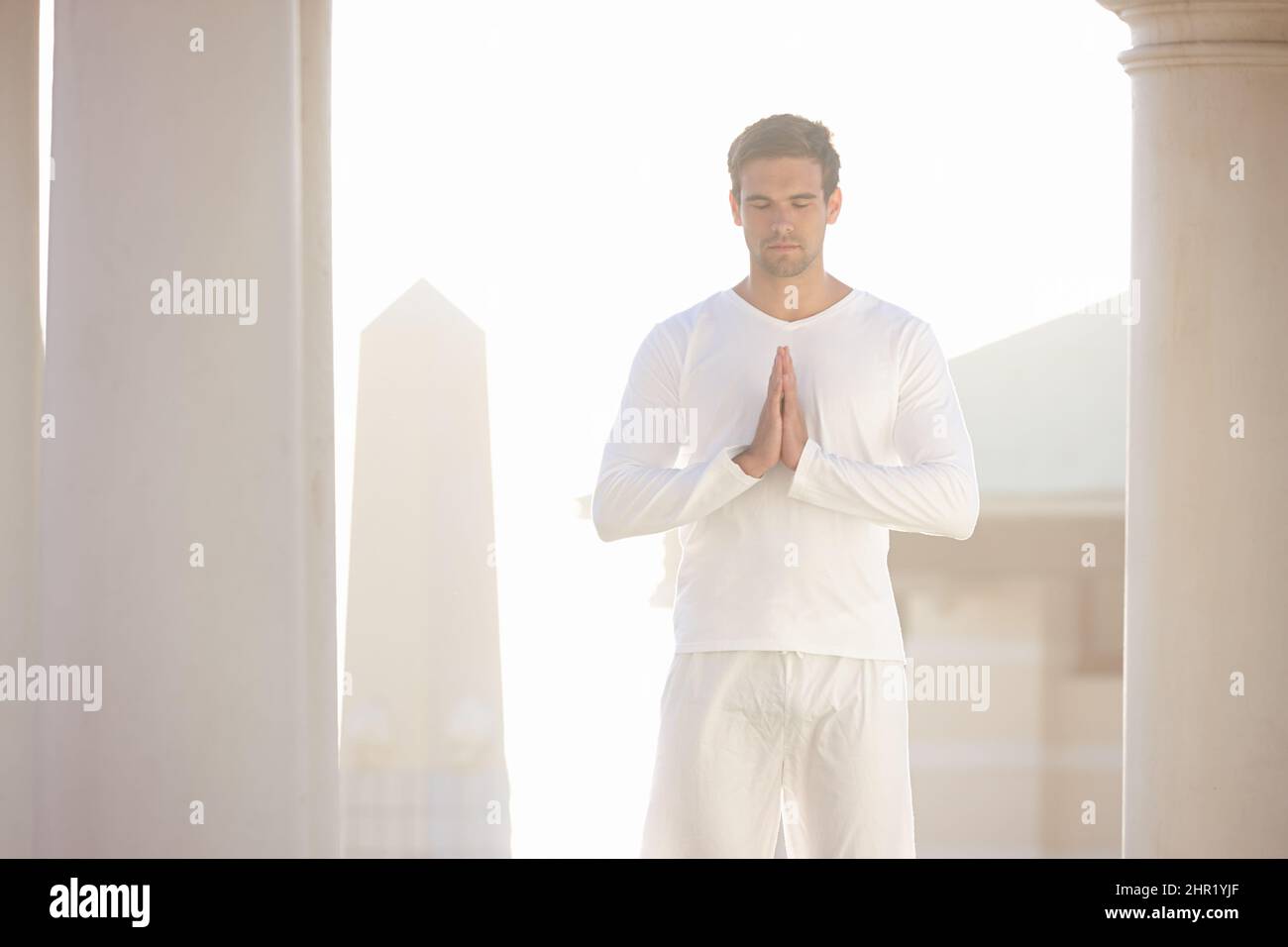 Den Tag in Ruhe beginnen. Drei Viertel der Aufnahme eines jungen Mannes, der im Freien Yoga macht. Stockfoto