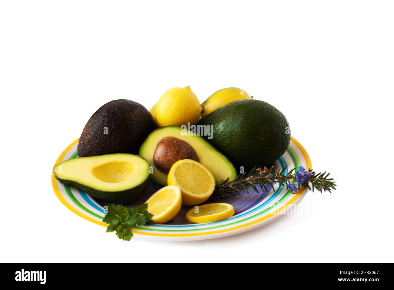 Alles, was man für eine Guacomole braucht. Ein Teller mit Kräutern, Avos und Zitronen. Stockfoto