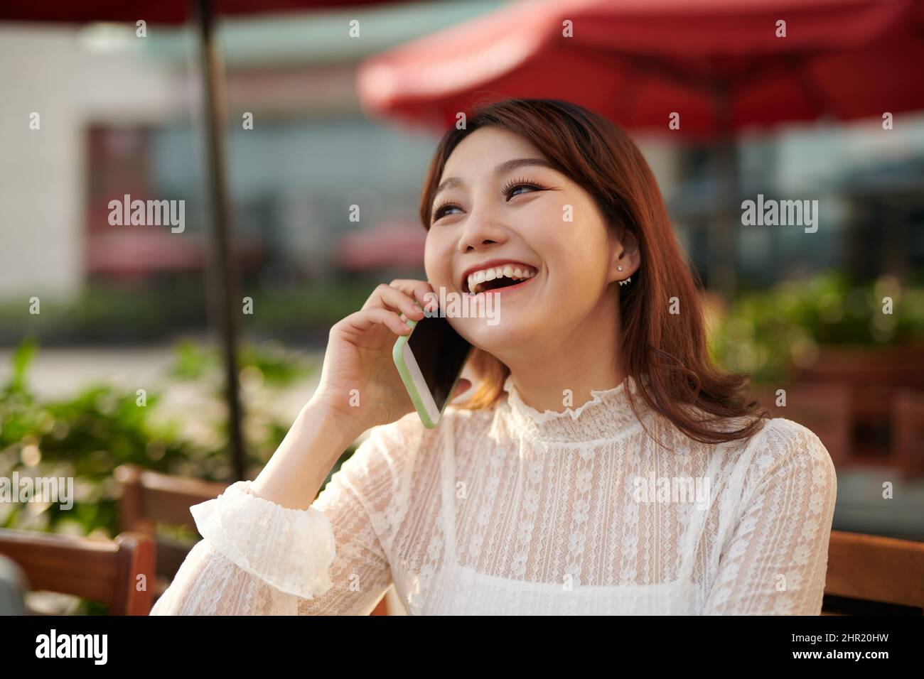 Ein Schuss von einer asiatischen Frau am Telefon sprechen Stockfoto