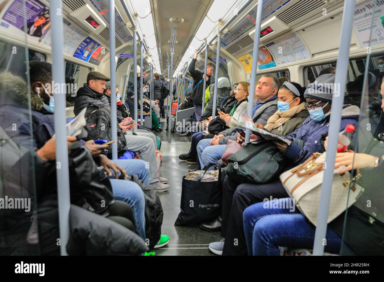 London, Großbritannien. 24.. Februar 2022. Passagiere in einem Londoner U-Bahn-Wagen, viele davon jetzt ohne Gesichtsmaske.der Bürgermeister von London hat angekündigt, dass Facemasken im öffentlichen Verkehr in London nicht mehr benötigt werden, was die Hauptstadt an die nationalen Entwicklungen anbringt, wo alle verbliebenen Covid-rechtlichen Einschränkungen beendet sind. Kredit: Imageplotter/Alamy Live Nachrichten Stockfoto