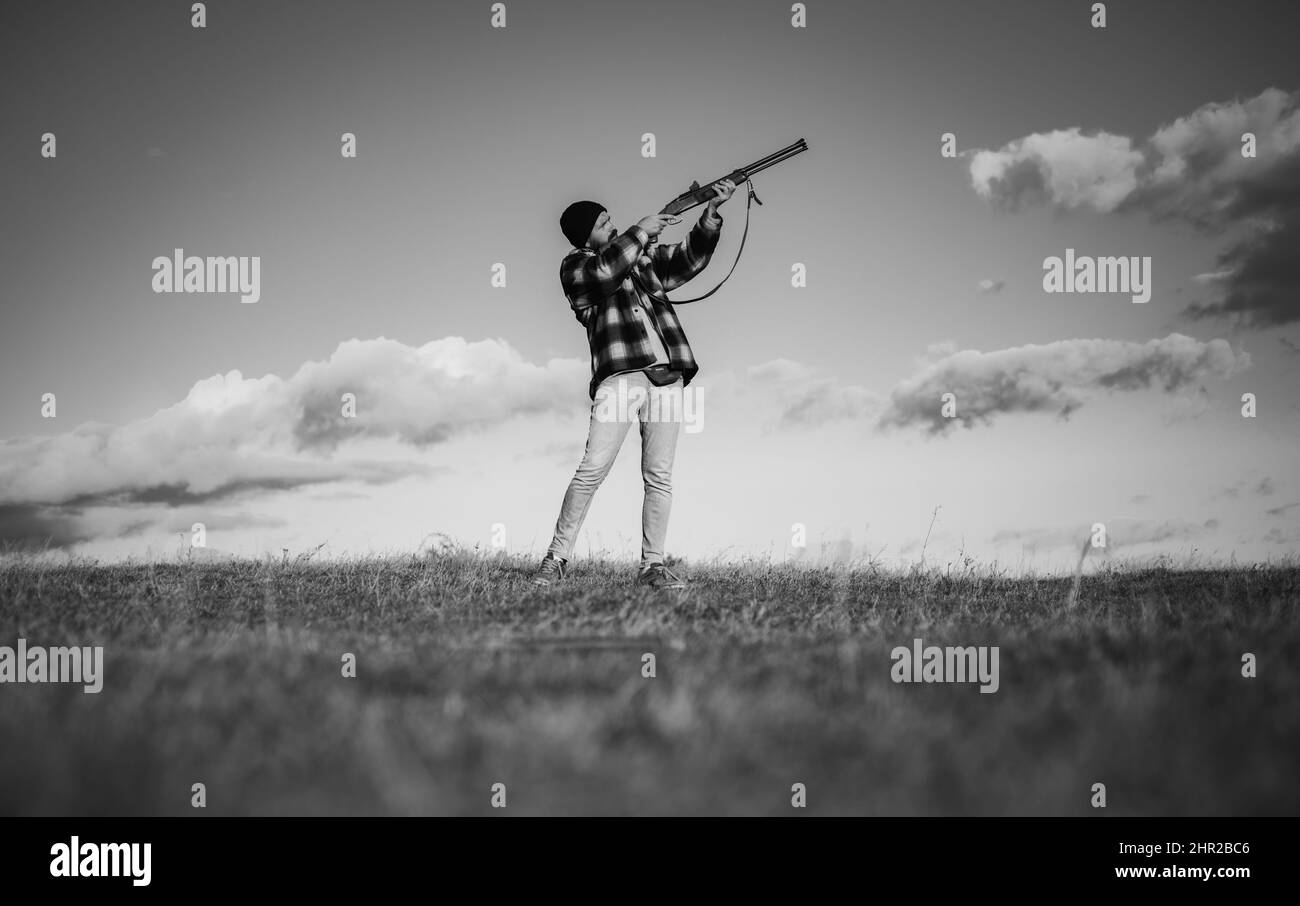 Sportliches Tonschießen und Skeet Shooting. Jäger mit Schrotflinte auf der Jagd. Autunm-Jagd. Jagd in den USA. Hunter zielt auf Gewehr im Wald. Prozess der Ente Stockfoto