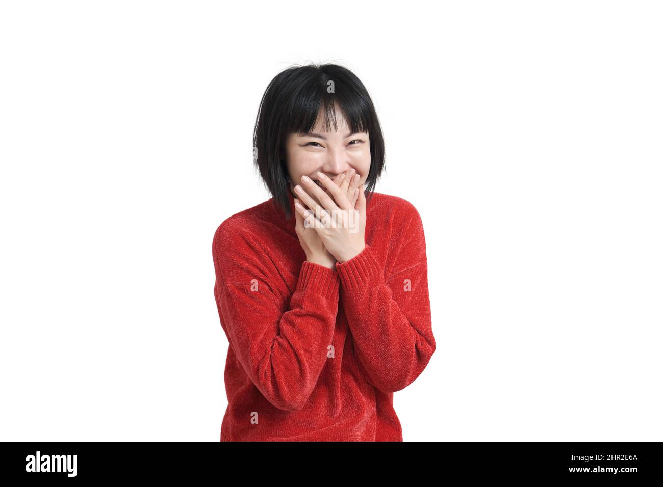 Junge asiatische Frau lachend und kichernd bedeckt den Mund mit Händen, isoliert. Stockfoto
