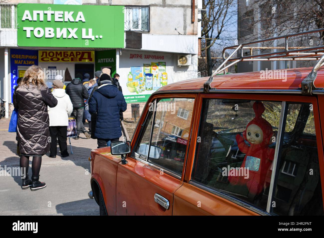 Die Menschen warten in einer Schlange vor einer Apotheke im Zentrum von Kramatorsk. US-Präsident Joe Biden kündigte neue Sanktionen gegen Russland an und sagte, Putin habe diesen Krieg gewählt und sein Land werde die Folgen tragen. Andere Nationen haben auch Sanktionen angekündigt oder sagten, sie würden es bald tun. Der Chef des NATO-Bündnisses, Jens Stoltenberg, sagte, dass der „brutale Akt des Krieges“ den Frieden in Europa erschütterte und sich einem Chor von Weltführern anschloss, die einen Angriff anprangern, der massive Verluste verursachen und die demokratisch gewählte Regierung der Ukraine stürzen könnte. Der Konflikt erschütterte die globalen Finanzmärkte: Aktien stürzten und Öl Stockfoto