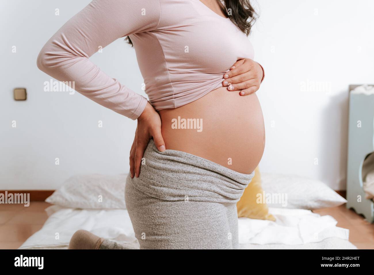 Nahaufnahme des großen erwartenden Bauch der Schwangeren im Bett mit Händen berühren. Schwangerschaft, Mutterschaft und Erwartung Konzept Stockfoto