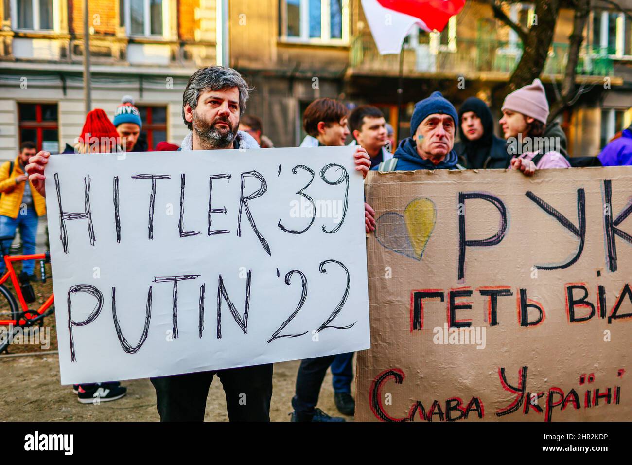 Ein Protestler hält während des Protestes ein Plakat mit der Aufschrift "Hitler '39, Putin '22". Als Reaktion auf den russischen Einmarsch in die Ukraine protestierten Mitglieder der ukrainischen Gemeinschaft sowie unterstützende Polen und Weißrussen in der Nähe der diplomatischen Vertretungen der Russischen Föderation, um ihre Opposition gegen die russische militärische Aggression auszudrücken. In Krakau, wo die ukrainische Einwanderung besonders zahlreich ist, marschierten mehrere tausend Menschen durch das Stadtzentrum und versammelten sich vor dem russischen Konsulat. (Foto von Filip Radwanski/SOPA Images/Sipa USA) Stockfoto