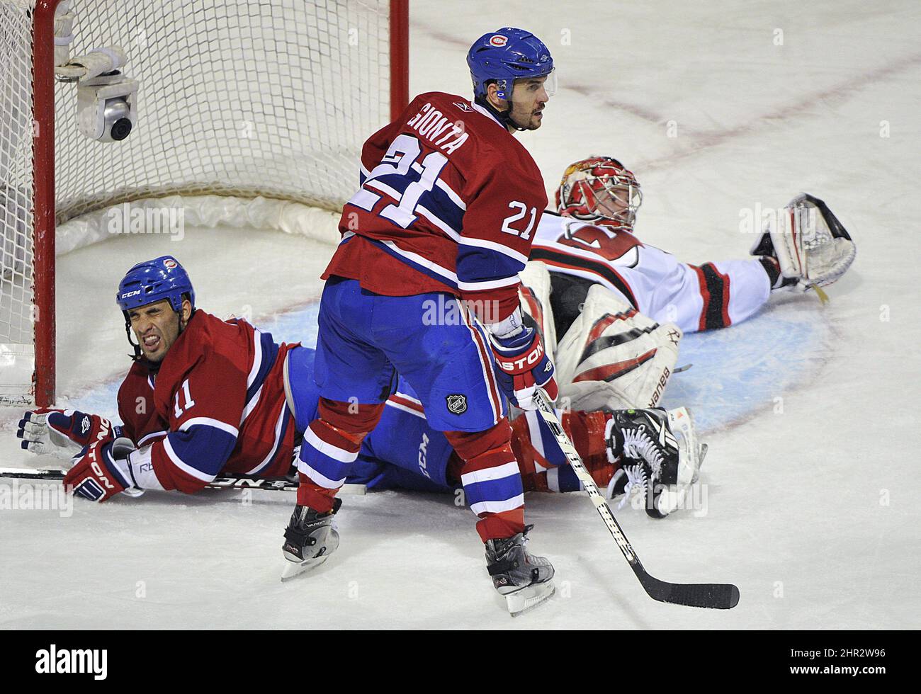Montreal Canadiens 'Scott Gomez (11) reagiert nach der Kollision mit New Jersey Devils' Torhüter Johan Hedberg, rechts, als Canadiens 'Brian Gionta (21) sieht während der dritten Periode NHL Hockey Aktion in Montreal, Sonntag, 6. Februar 2011. DIE KANADISCHE PRESSE/Graham Hughes Stockfoto