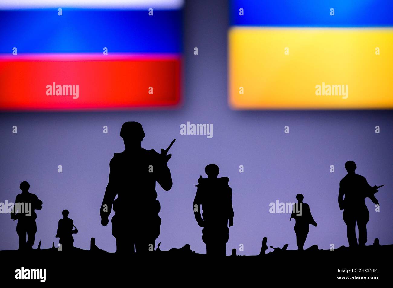 Krieg in der Ukraine. Russland greift die Ukraine an. Illustration Foto. Silhouette der Soldaten, Nationalflagge im Hintergrund. Konflikt in Europa Stockfoto