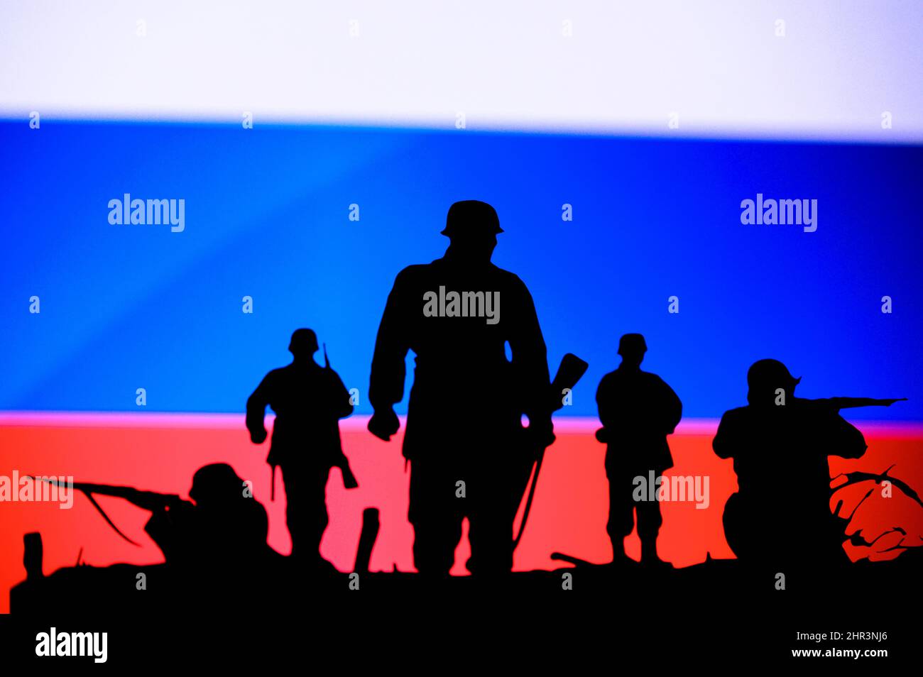 Krieg in der Ukraine. Russland greift die Ukraine an. Illustration Foto. Silhouette der Soldaten, Nationalflagge im Hintergrund. Konflikt in Europa Stockfoto