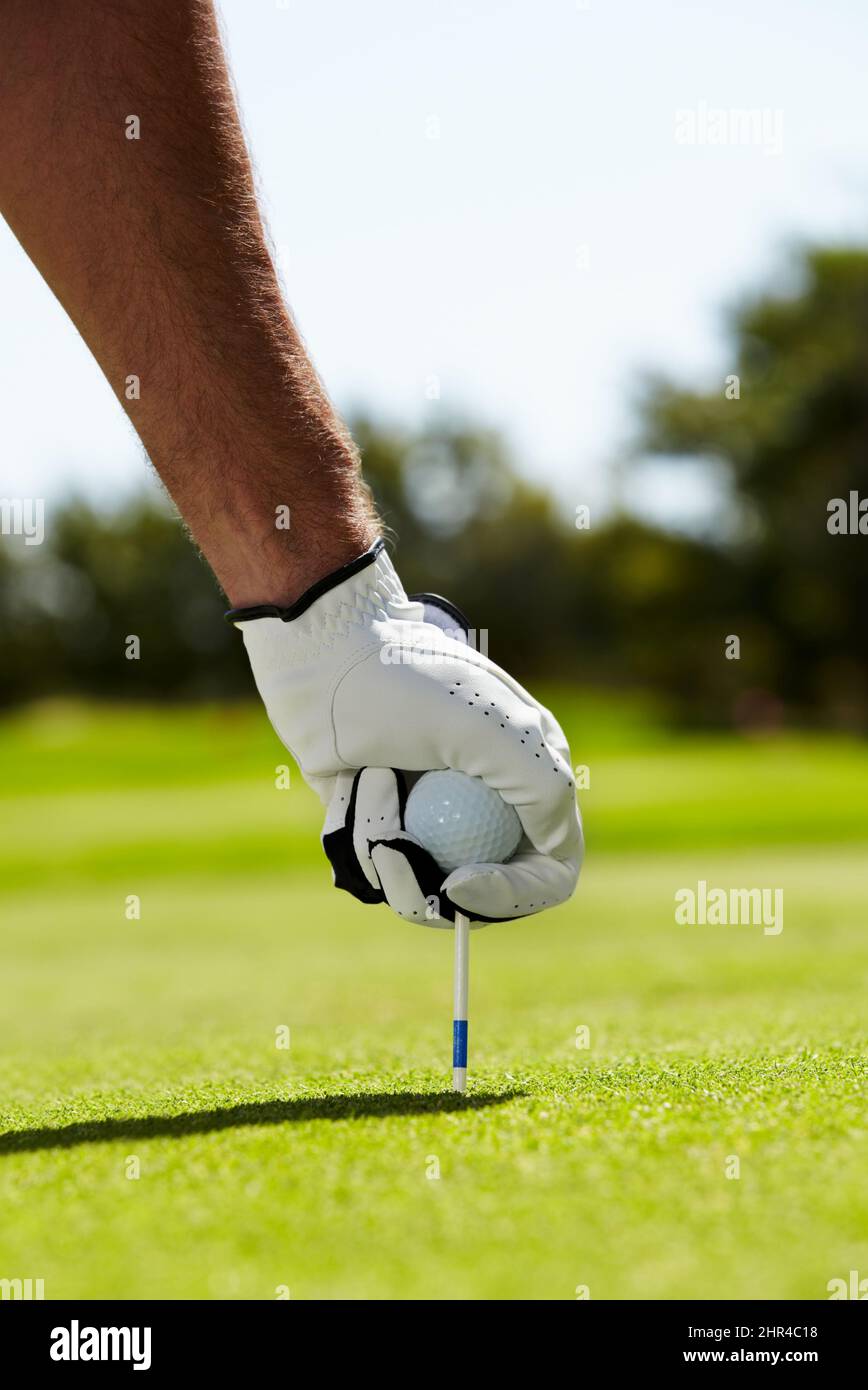 Die Routine vor dem Loch. Ein Golfer, der sein T-Shirt auf dem Golfplatz in den Boden legt. Stockfoto