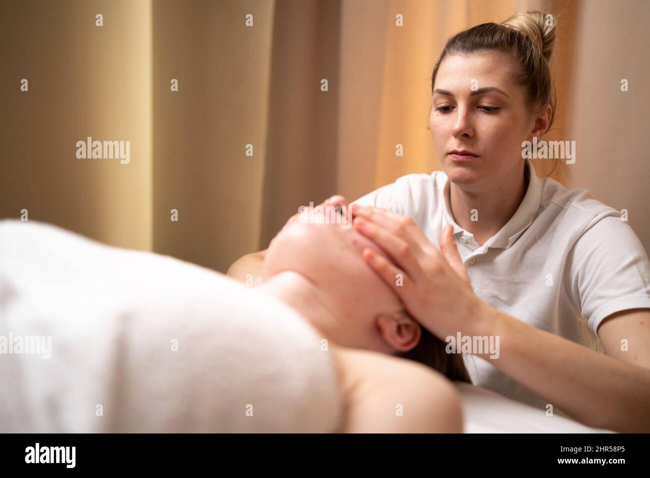 Masseur Therapeut tun Gesichtsmassage der Frau im Spa-Salon, verjüngende Gesichtsmassage Verfahren, gesunde Haut und Körper Konzept. Spa-Behandlungen in einem Stockfoto