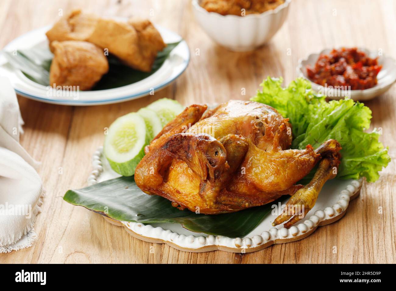 Tiefgebratenes, gebratenes Hähnchen, serviert mit Gurke, Gemüse und Sambal. Indonesisch beliebte Beilage oder Bakakak Hayam Stockfoto